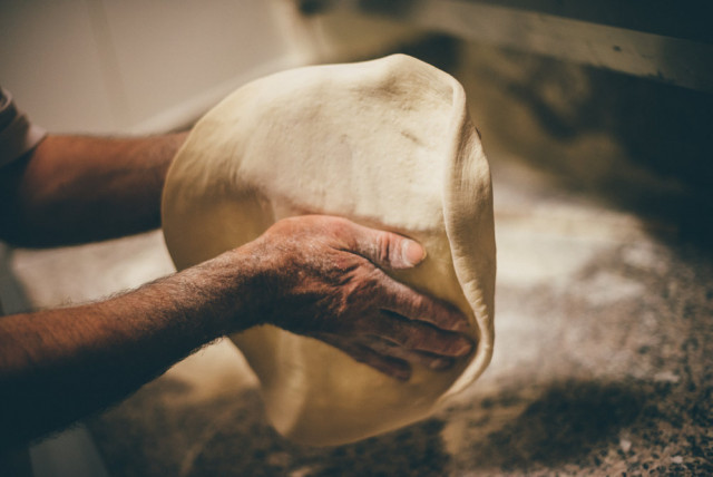 Man tossing pizza dough